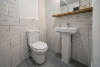 Deuxième salle de bain compacte et moderne avec toilette blanche et carrelage gris dans une maison familiale